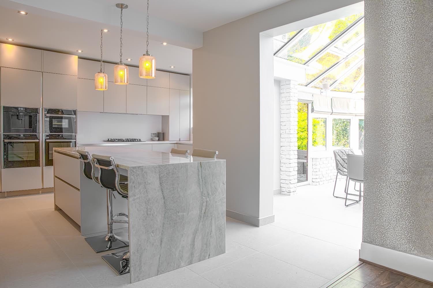 Open-plan kitchen leading into a bright glazed extension with a skylight roof
